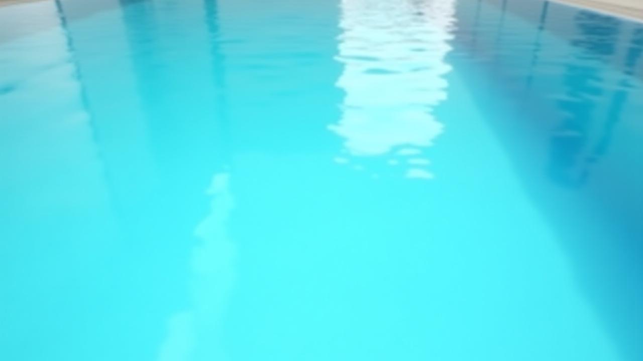 完全に透明で穏やかなプール水面。水面に反射する建築的な光。